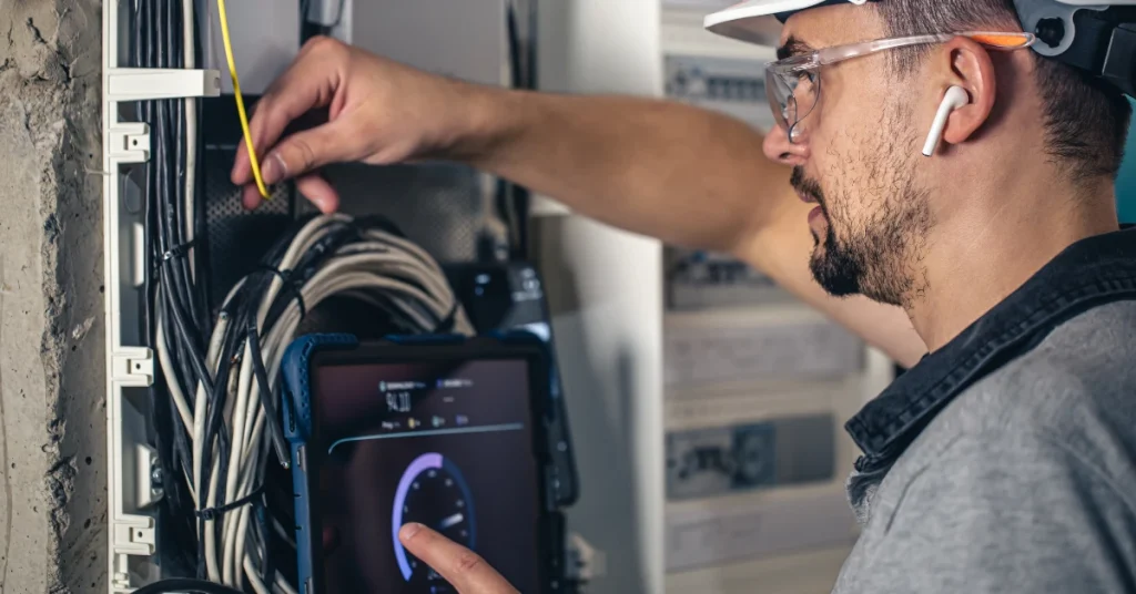 Technician Performing Data Point Installation On Network Cables